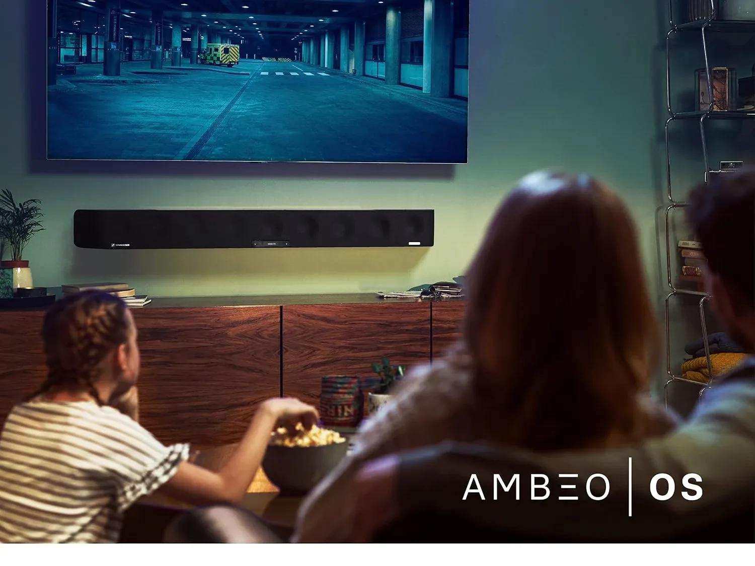 A family watching a film with the AMBEO Soundbar Max under a wall-mounted television