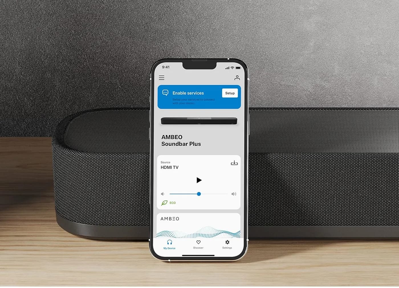 The Sennheiser Smart Control app open on a phone beside the AMBEO Soundbar Plus